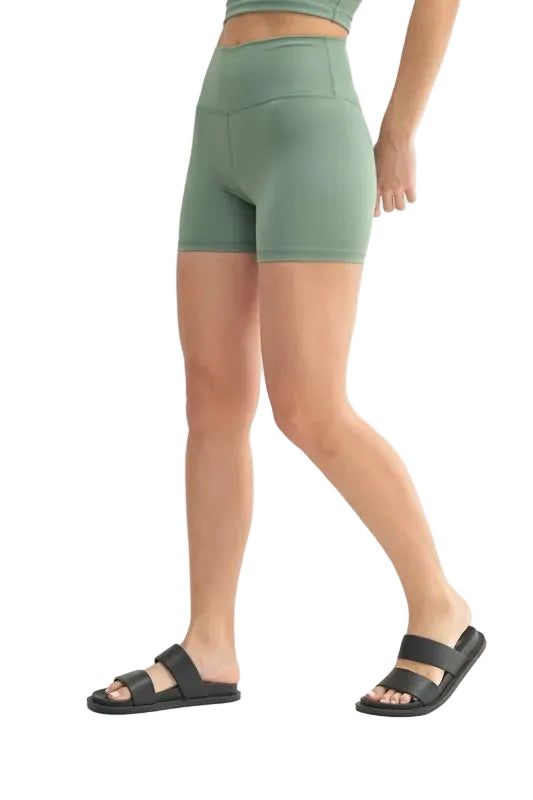 Person wearing green athletic shorts on a white background