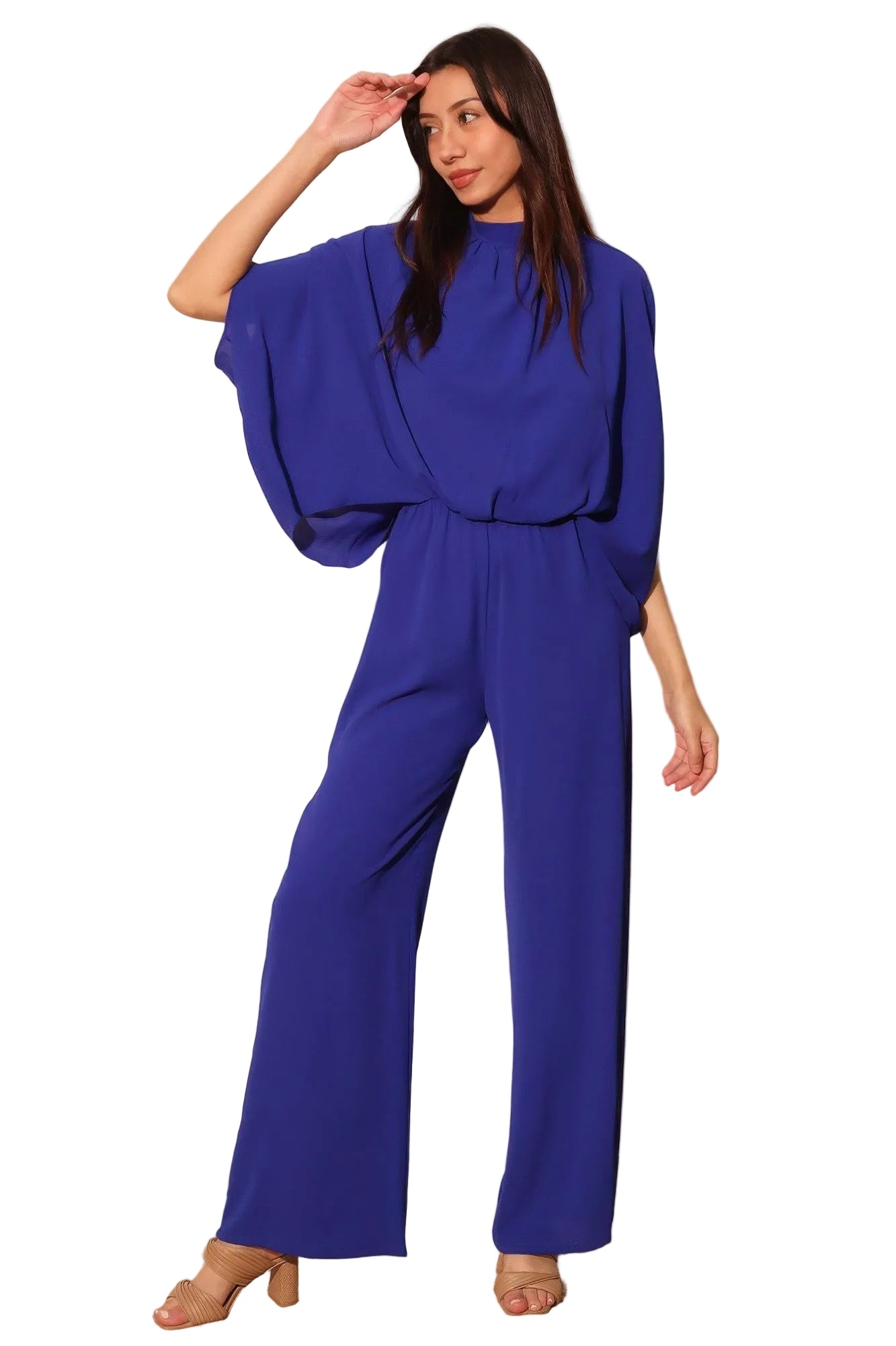 Woman wearing a blue jumpsuit against a plain background