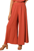Person wearing coral-colored wide-leg pants against a neutral background