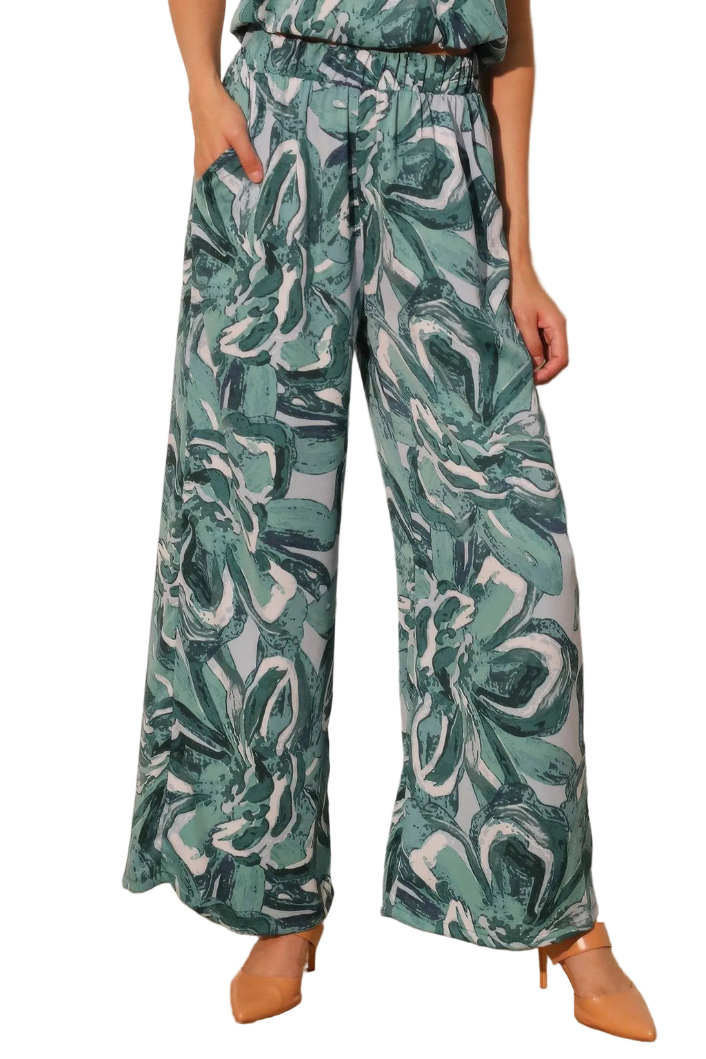 Person wearing teal and white patterned pants against a plain background