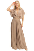 Woman wearing a beige wide leg pant on a plain background