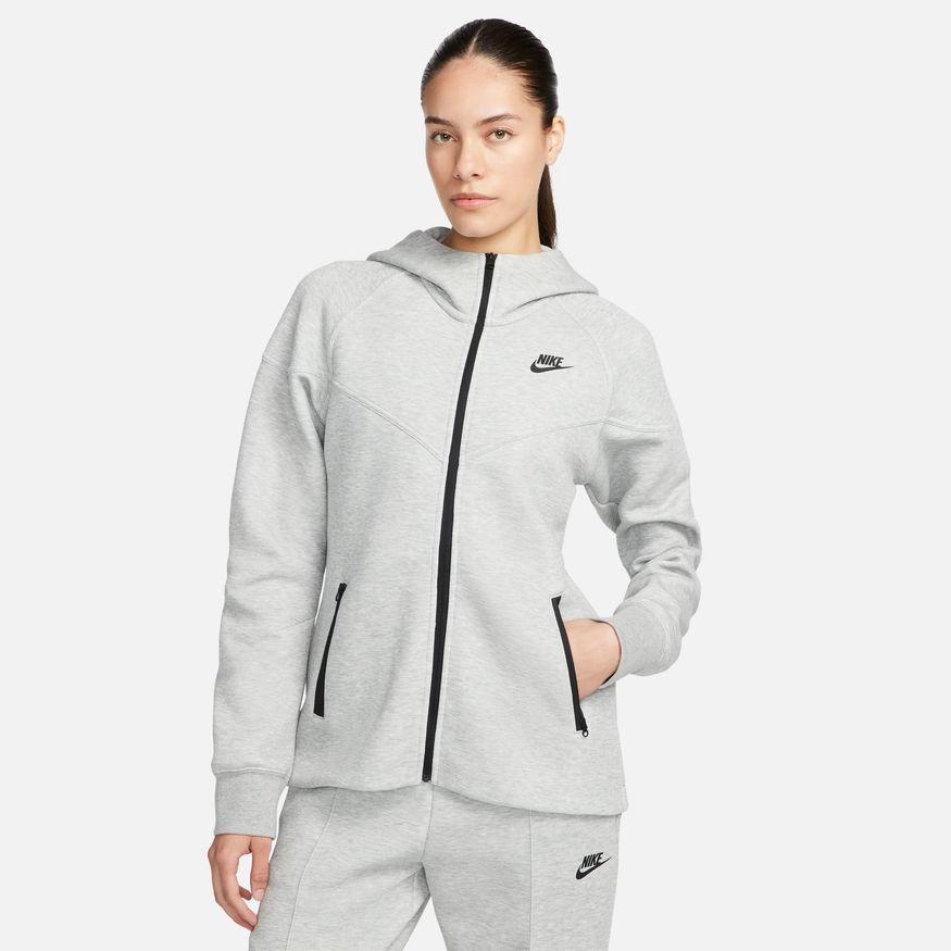 Woman wearing a gray Nike tracksuit on a white background