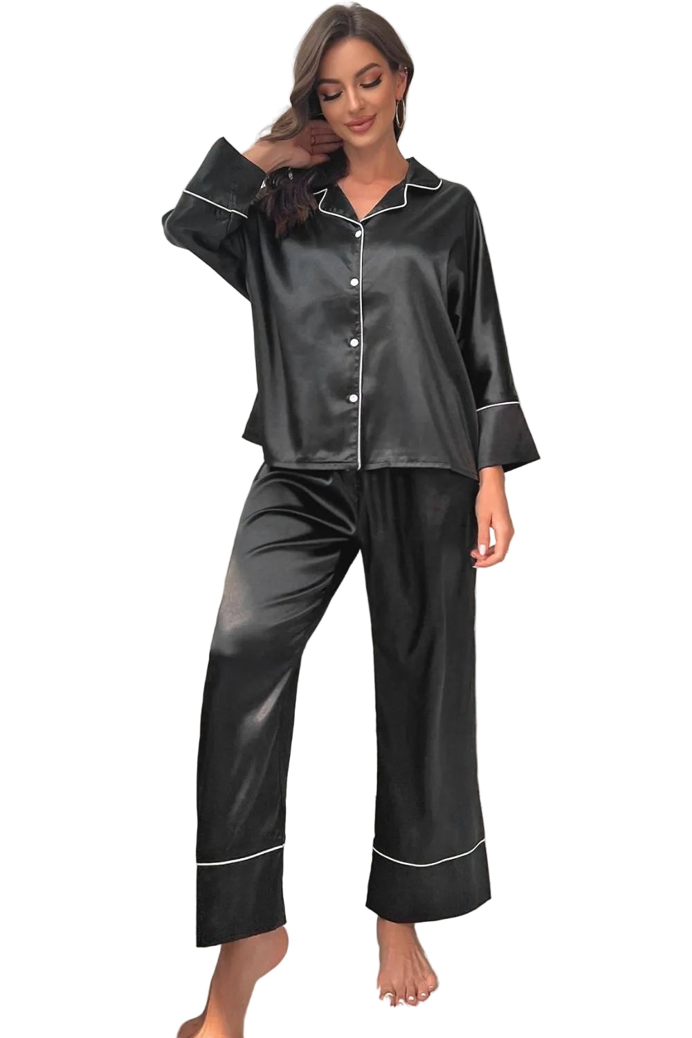 Woman wearing black satin pajamas in a cozy room.