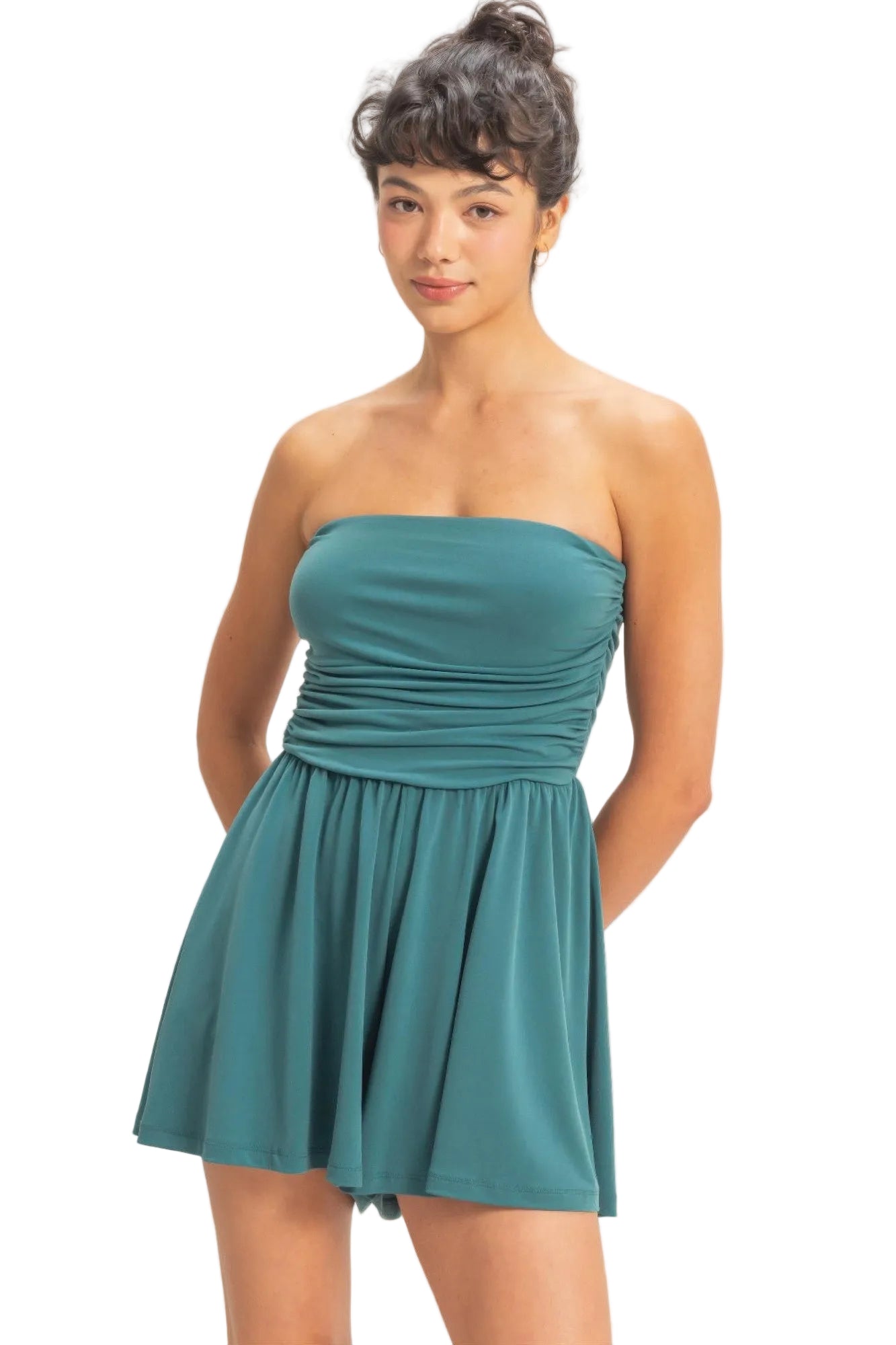 Woman wearing a teal strapless dress on a plain background