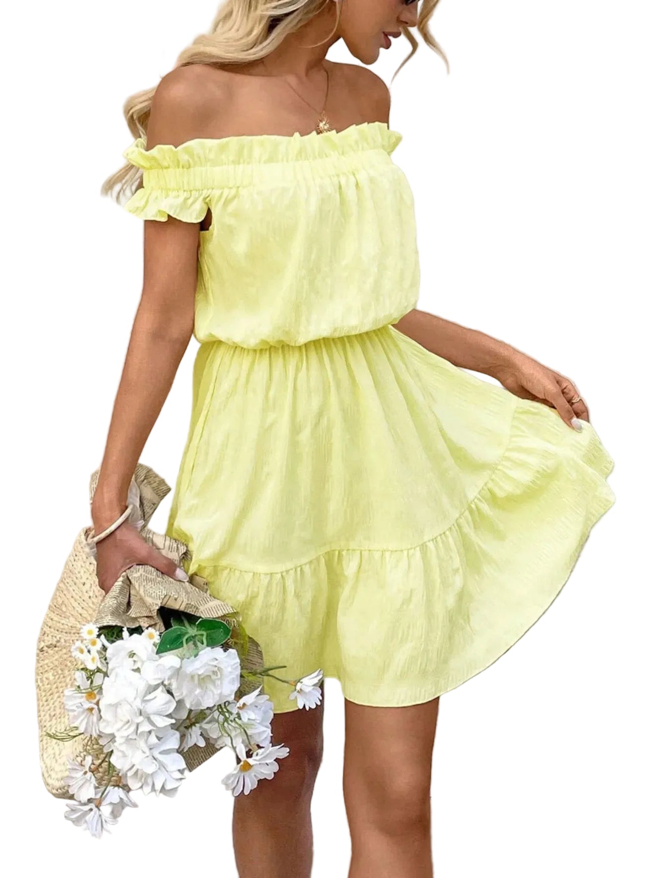 Woman wearing a yellow off-shoulder dress holding flowers and a straw bag against a light-colored wall.