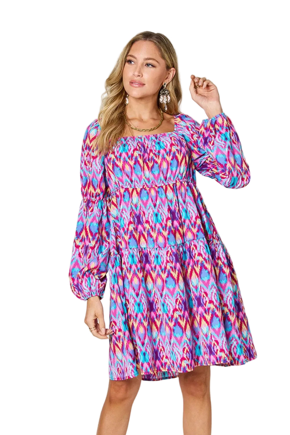 Woman wearing a colorful patterned dress against a plain background