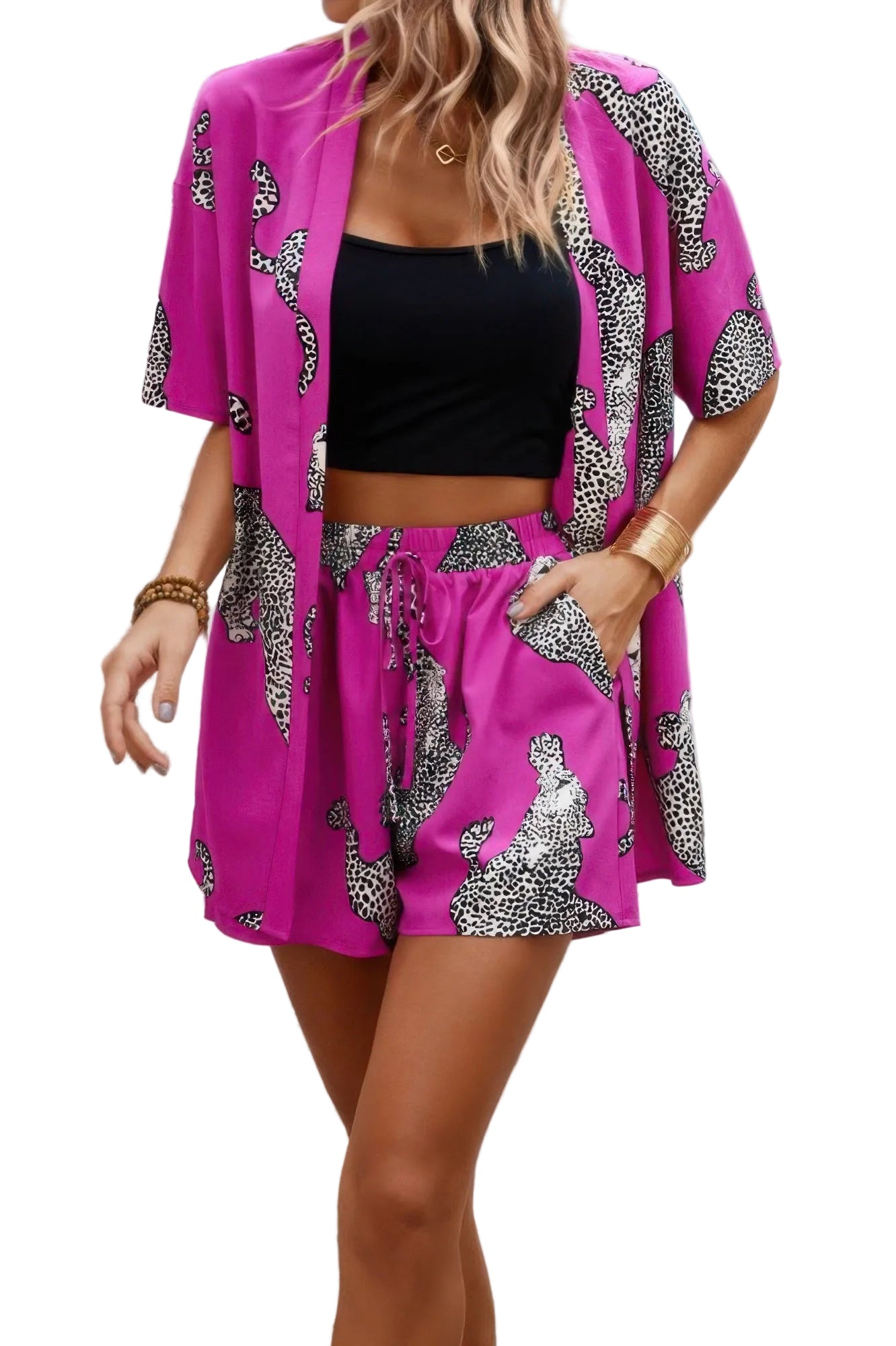 Woman wearing a pink outfit with black and white patterned kimono-style jacket and shorts, standing on stone steps.