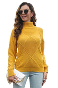 Woman wearing a mustard yellow sweater with a heart pattern, standing outdoors.