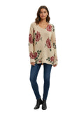 Woman wearing a beige sweater with red floral patterns on a white background