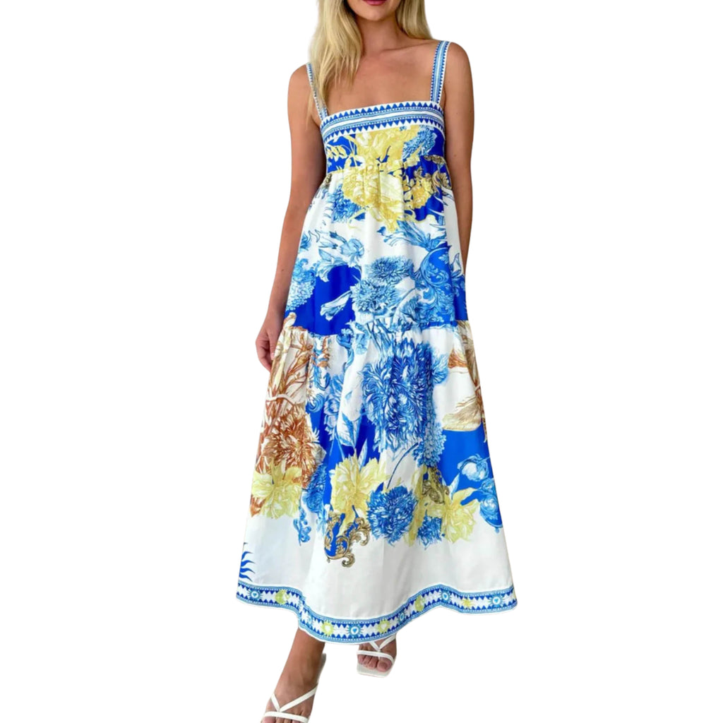 Woman wearing a floral dress with blue and yellow flowers on a white background