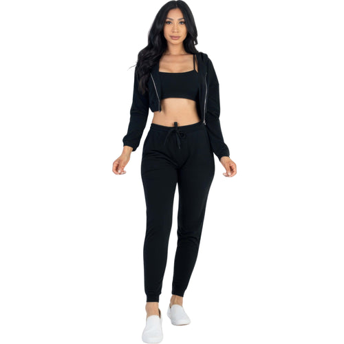 Woman wearing a black jogger set on a white background