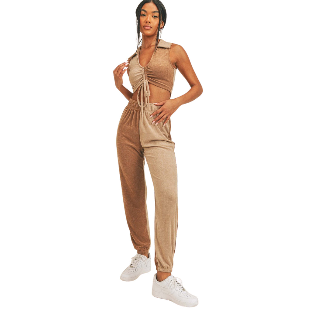 Woman wearing a beige jumpsuit with white sneakers on a white background