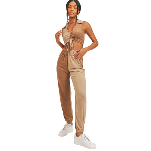 Woman wearing a beige jumpsuit with white sneakers on a white background