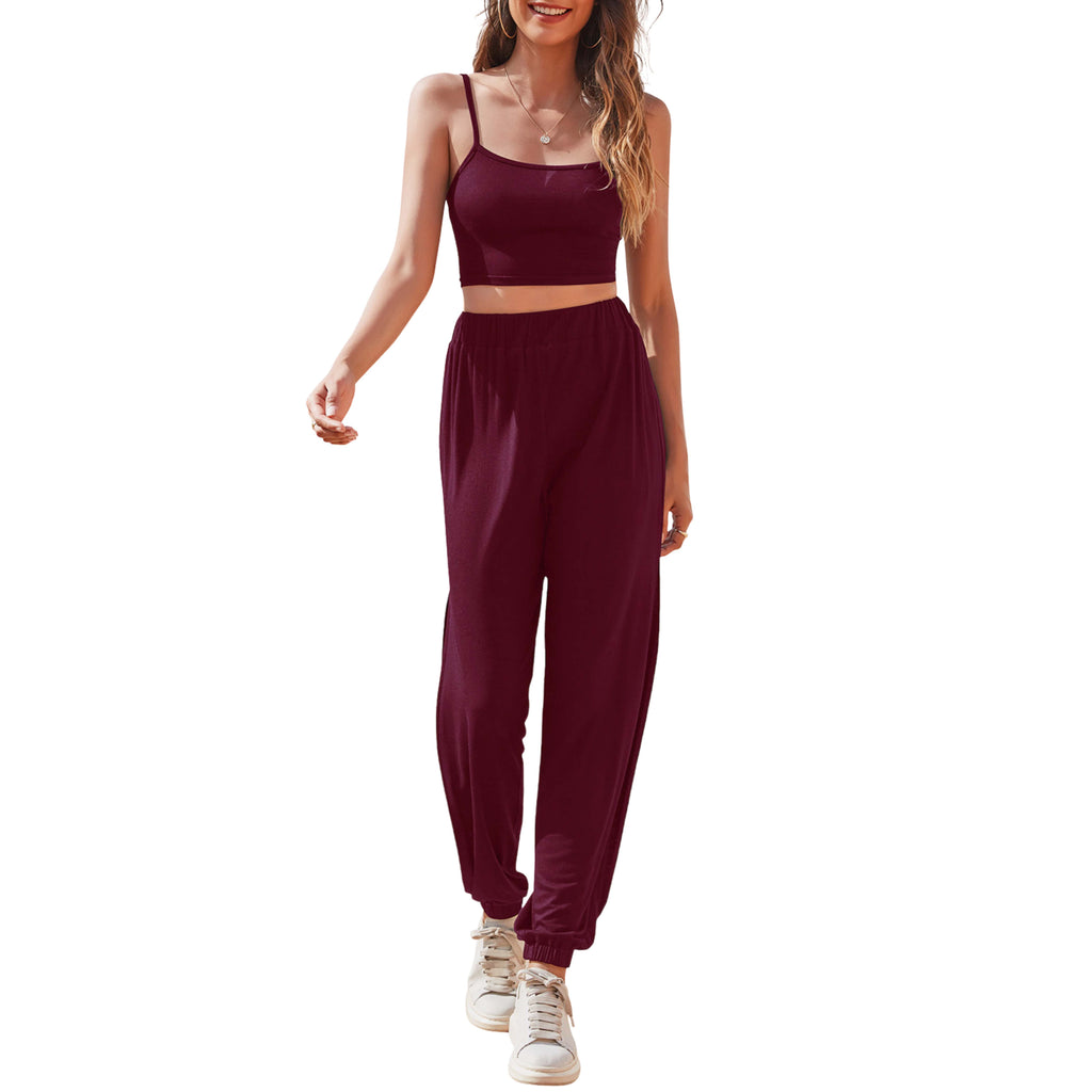 Woman wearing a burgundy sports bra and jogger pants on a white background