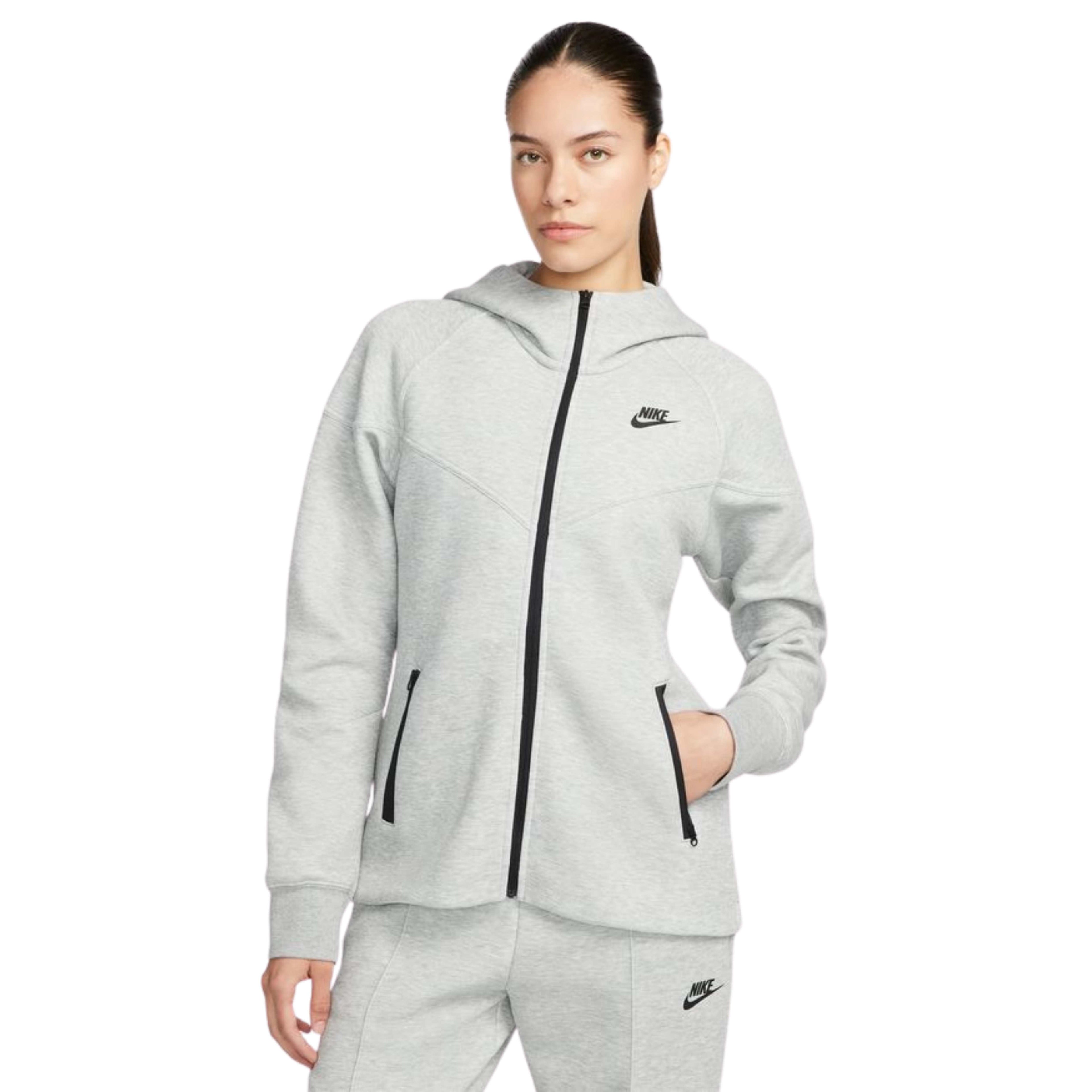 Woman wearing a gray Nike hoodie with a black zipper on a white background