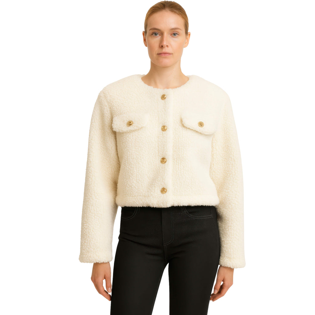 Woman wearing a cream-colored textured jacket with gold buttons on a white background