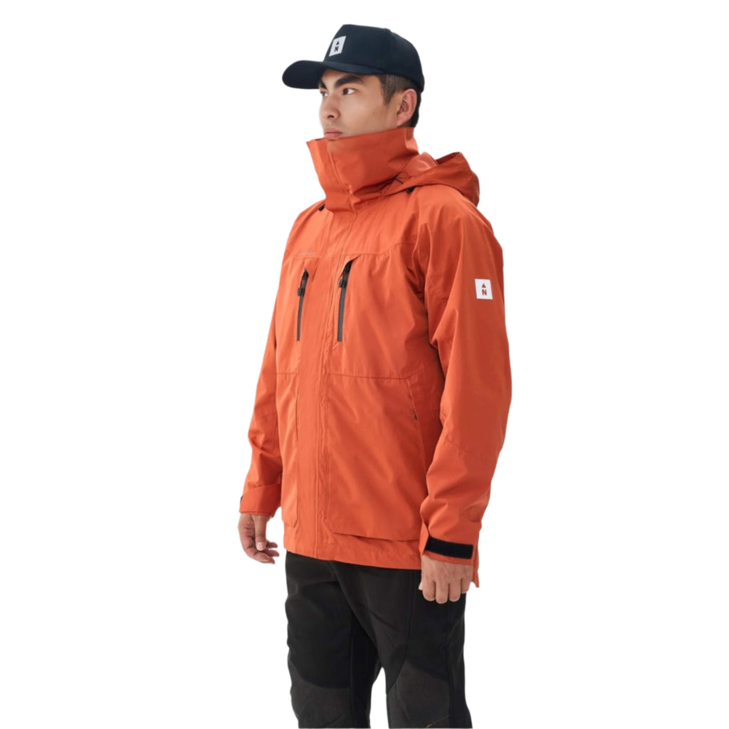Person wearing an orange waterproof jacket and black pants on a white background
