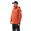 Person wearing an orange waterproof jacket and black pants on a white background
