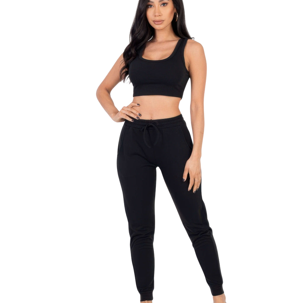 Woman wearing a black jogger set outfit on a white background