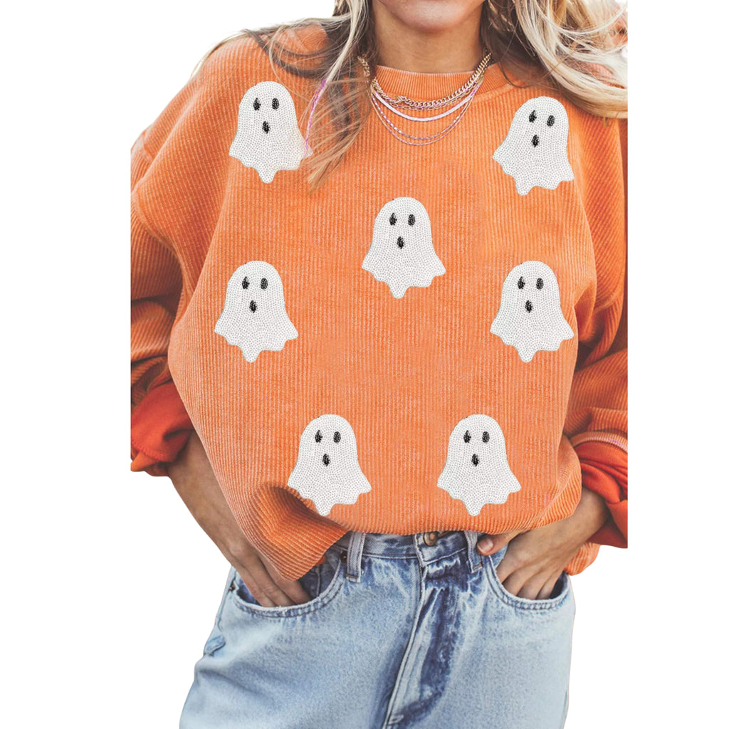 Person wearing an orange sweater with ghost patterns on a white background