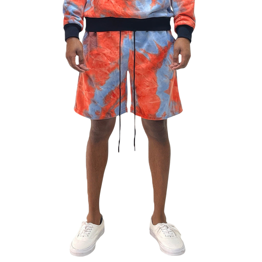 Person wearing a tie-dye outfit with shorts and a jacket on a white background