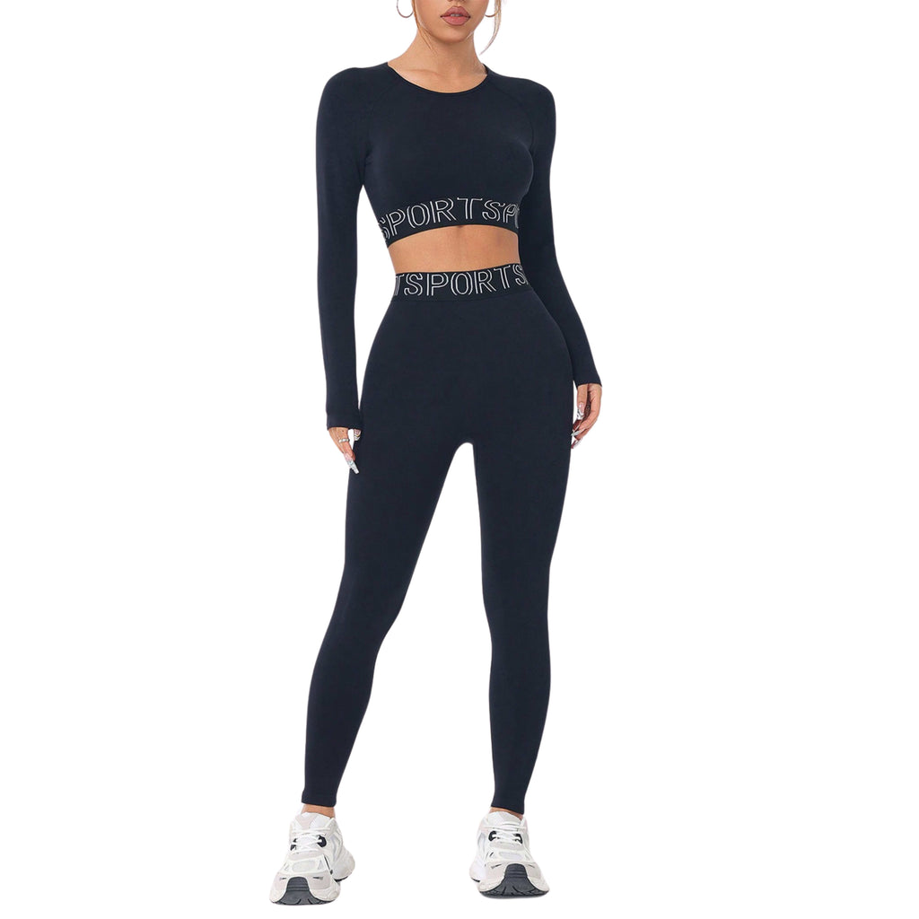 A woman wearing a round neck long sleeve top and matching legging active set in black color with text on the top clothing item.