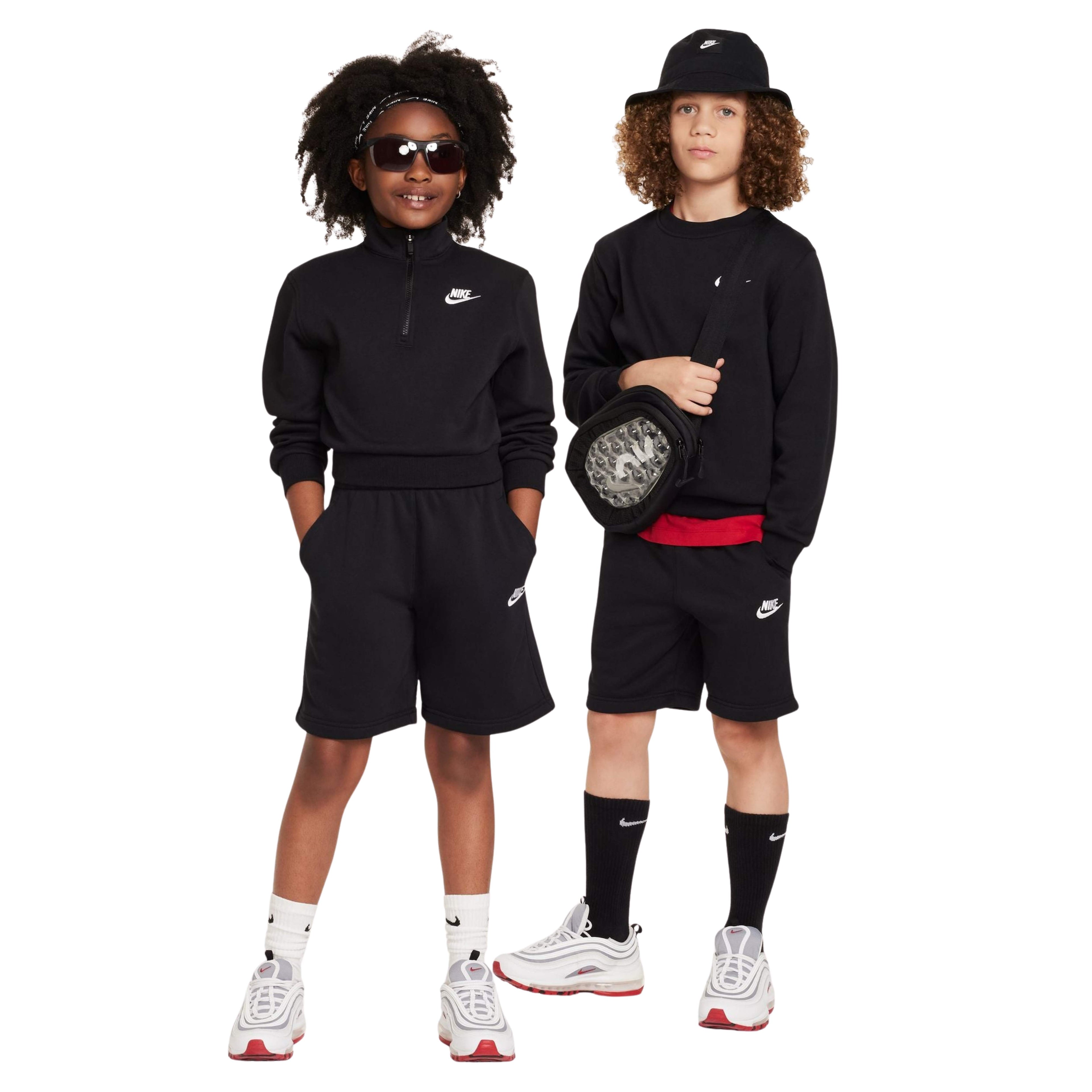 Two children wearing black Nike outfits on a white background