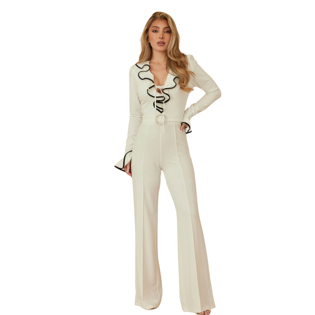 Woman wearing a cream-colored jumpsuit with black accents on a white background