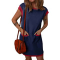 Woman wearing a blue dress with red accents holding a brown leather bag on a white background
