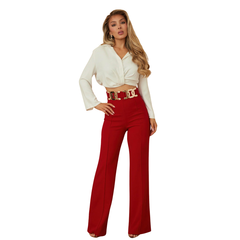 Woman wearing a white blouse and red pants on a white background