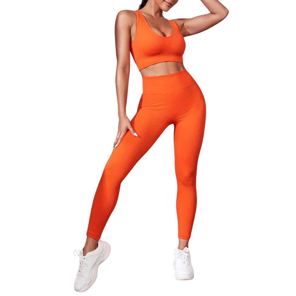 A women wearing an orange athletic sport tank and legging set on a white background