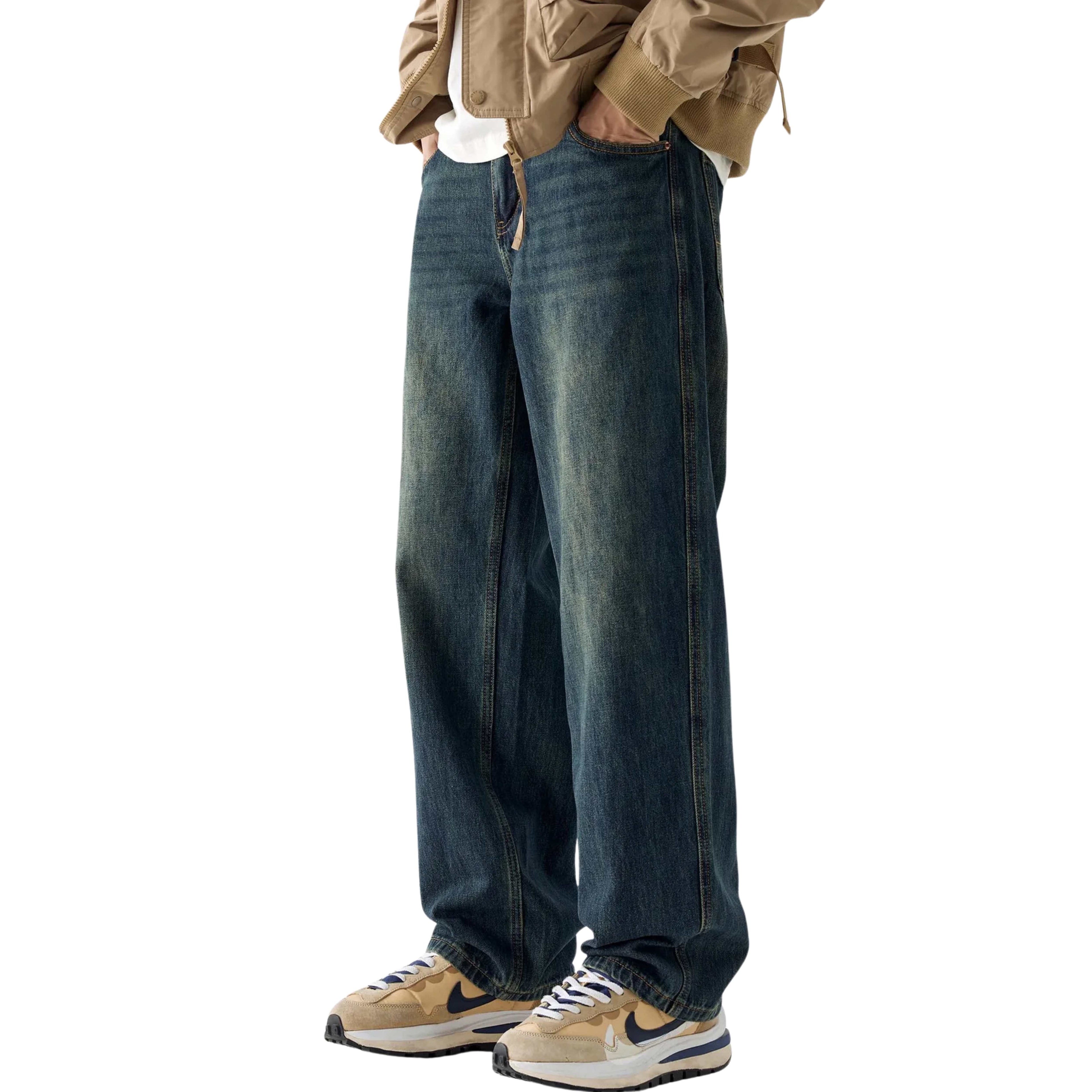 Person wearing wide-leg jeans and a beige jacket on a white background