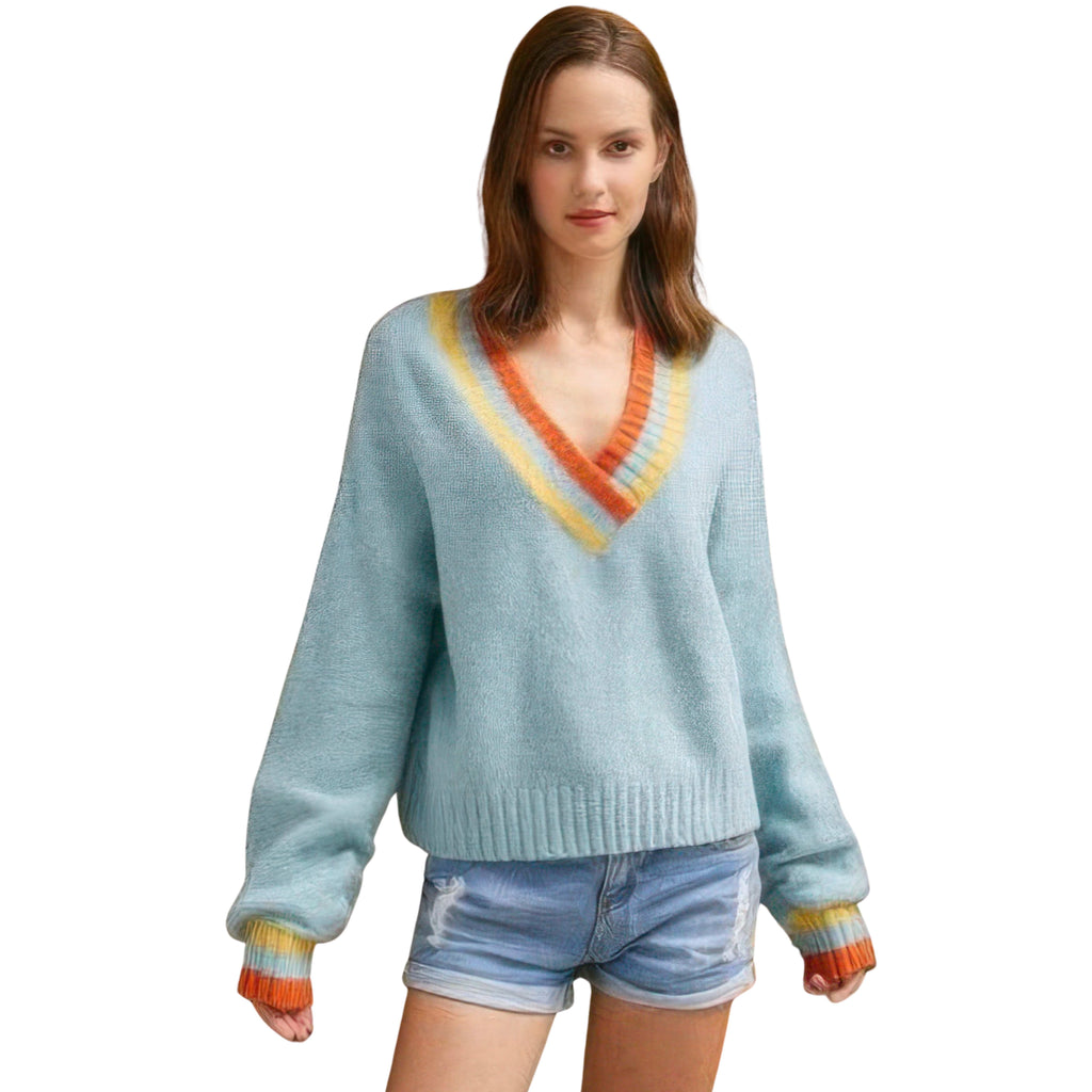 Woman wearing a light blue sweater with colorful trim on a white background