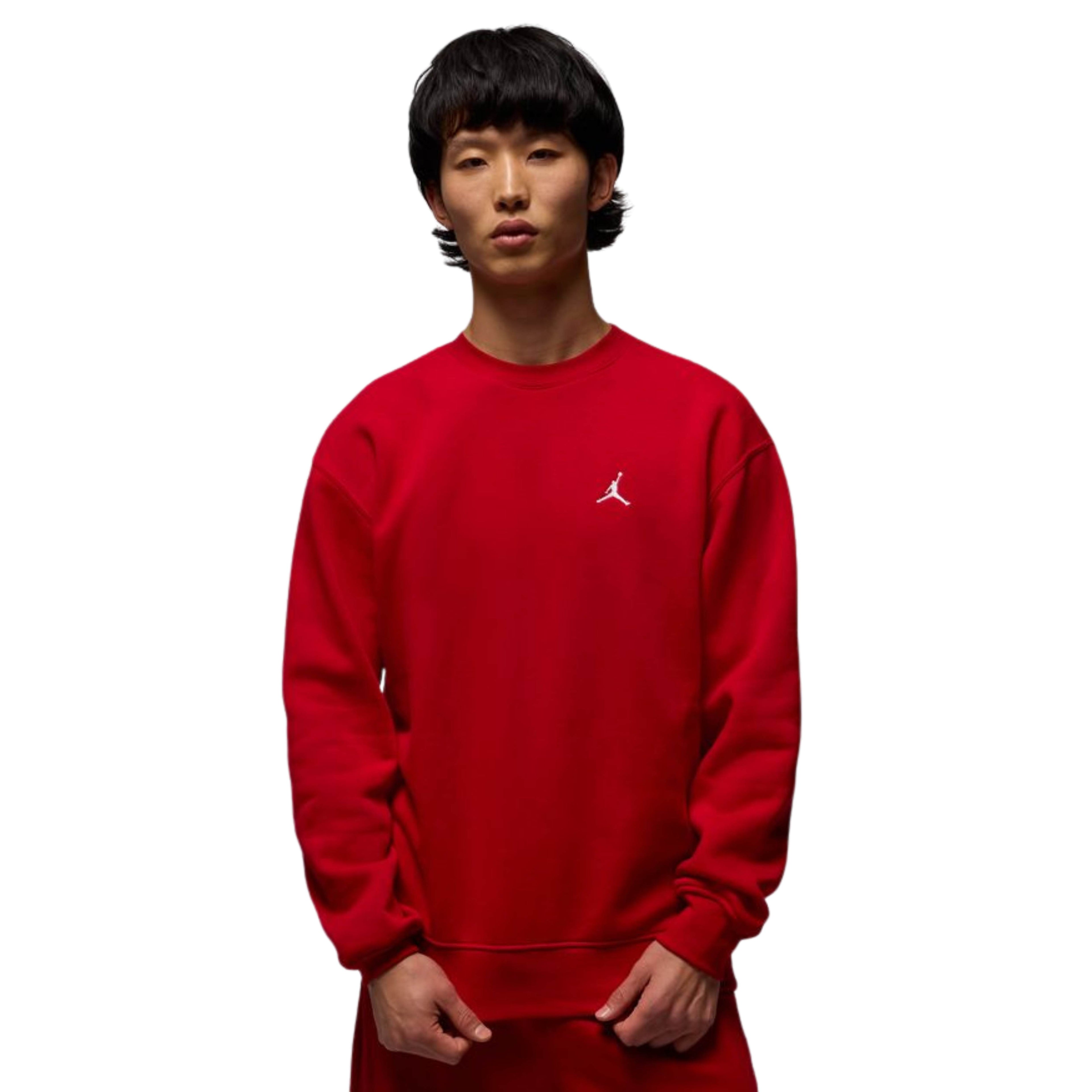 Person wearing a red sweatshirt with a logo on a white background