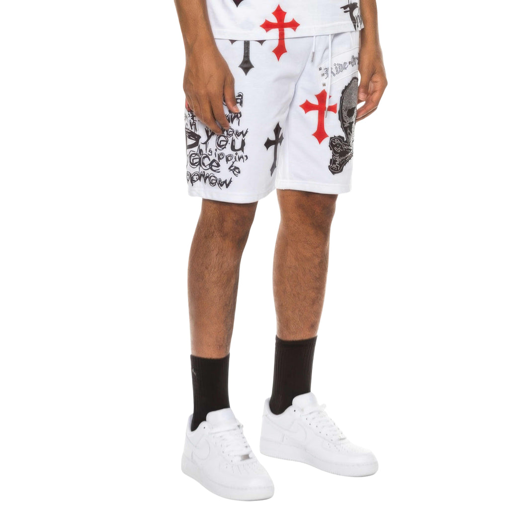 Person wearing white shorts with red and black designs on a white background