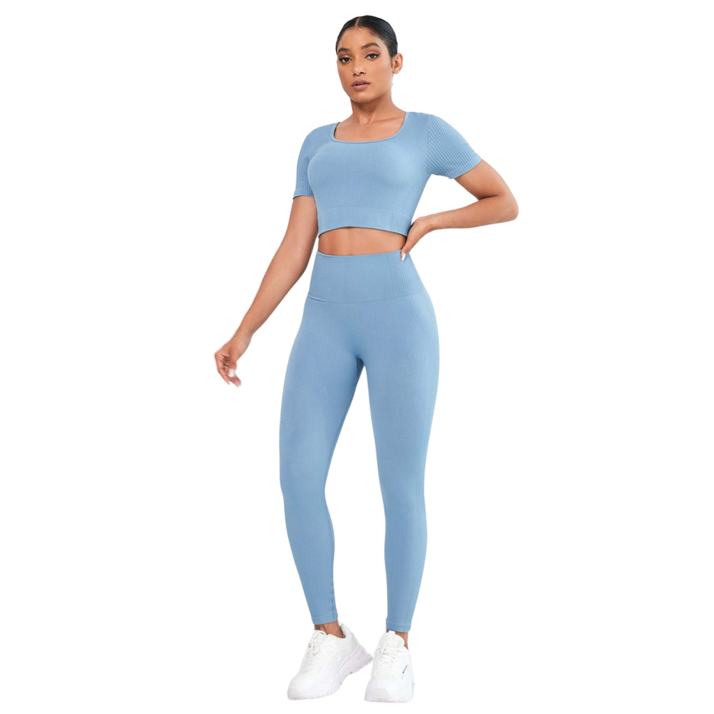 A woman wearing a blue short sleeve crop top and matching leggings.