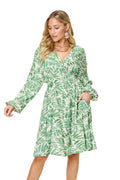 Woman wearing a green leaf-patterned dress on a white background