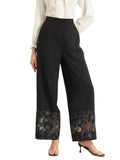 Black wide-leg pants with lace trim worn by a person on a gray floor.