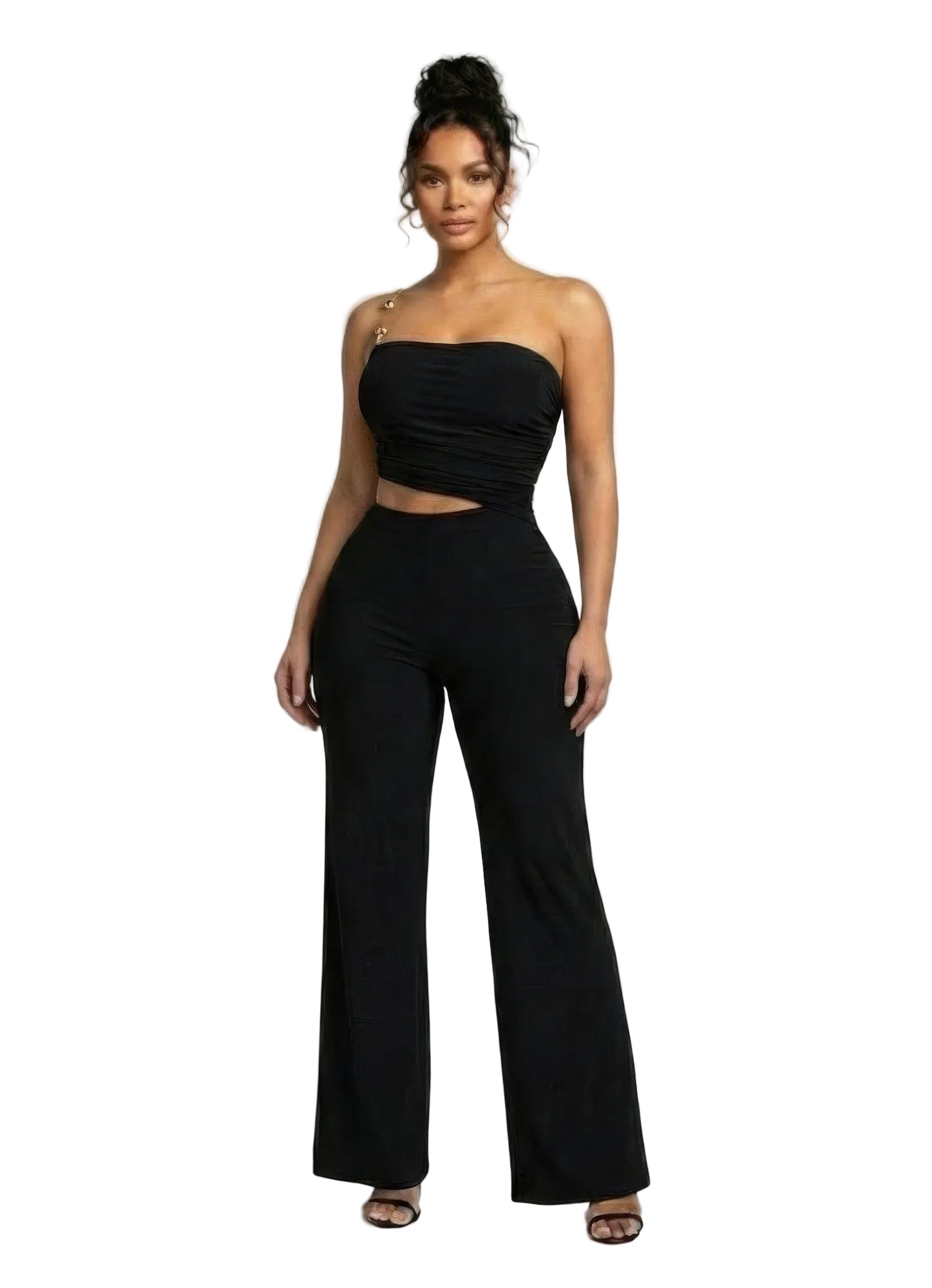 A woman wearing a black jumpsuit top and high-waisted pants on a plain background