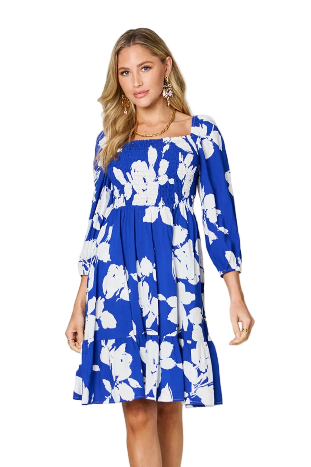 Woman wearing a blue floral dress against a plain background
