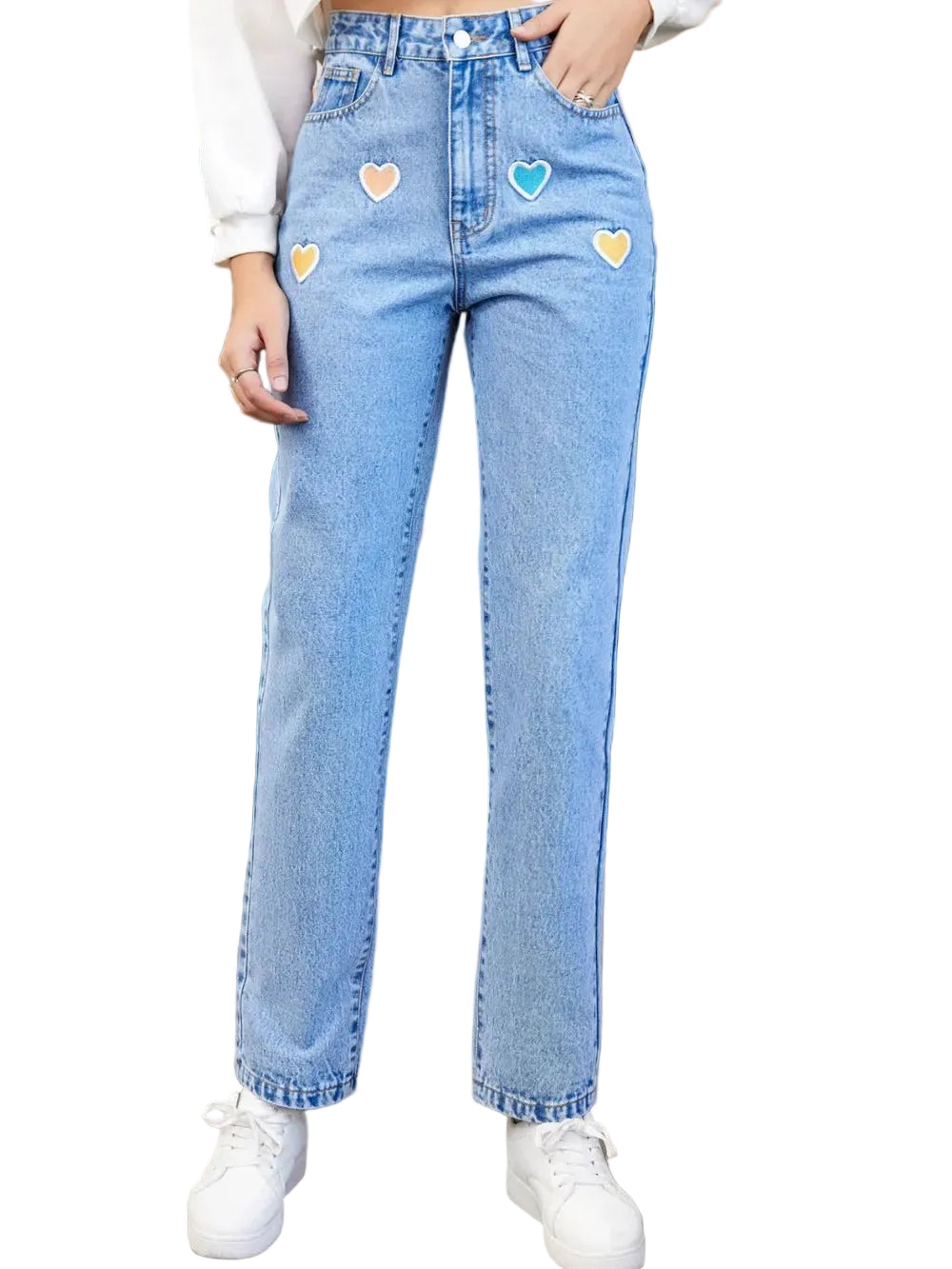 Person wearing light blue jeans with colorful heart patches in front of a green door.