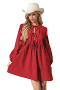 Woman wearing a red dress and white hat against a light background