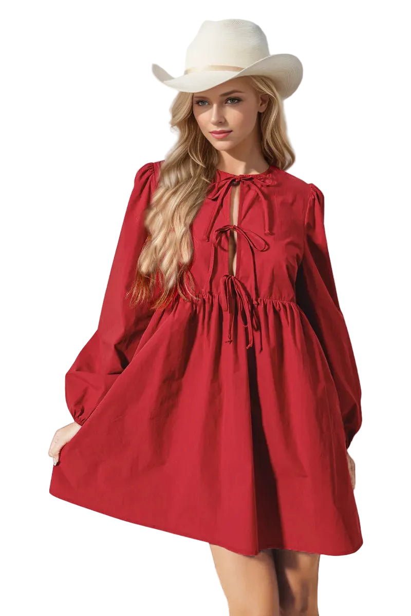 Woman wearing a red dress and white hat against a light background