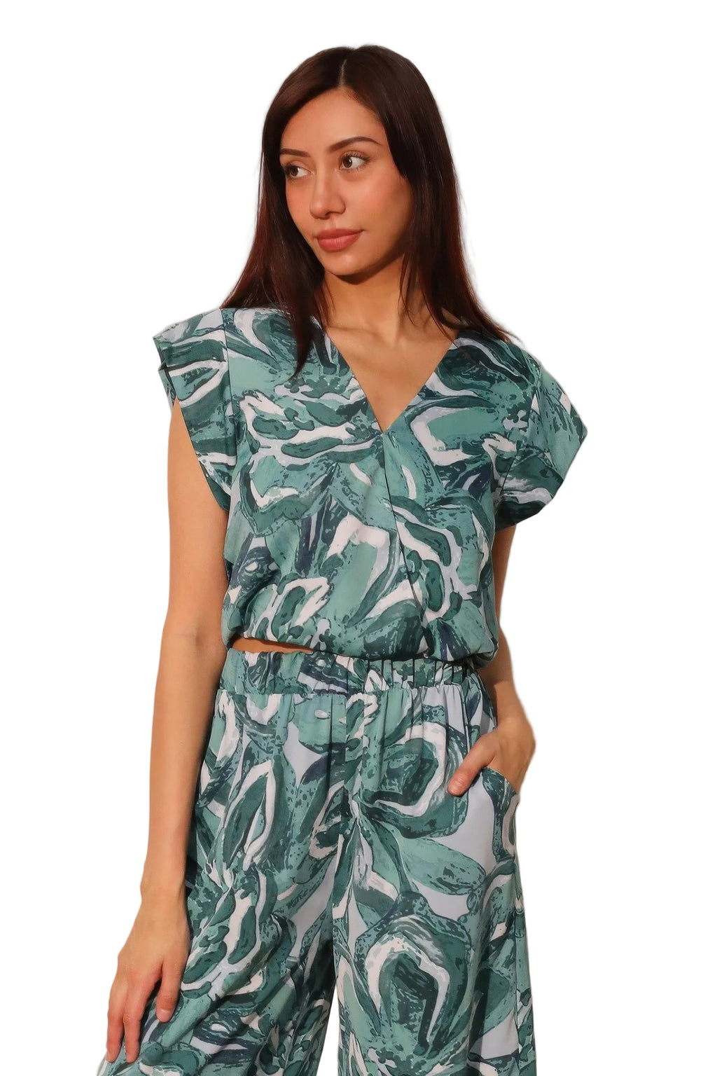 Woman wearing a green and white patterned outfit against a plain background