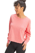 Woman wearing a pink long-sleeve top against a beige background