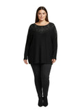 Woman wearing a black Plus Top with intricate detailing on a gray background