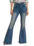 Flared jeans worn by a person on a light pink background