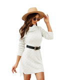 Woman wearing a white sweater dress with a beige hat and sunglasses against a white wall.
