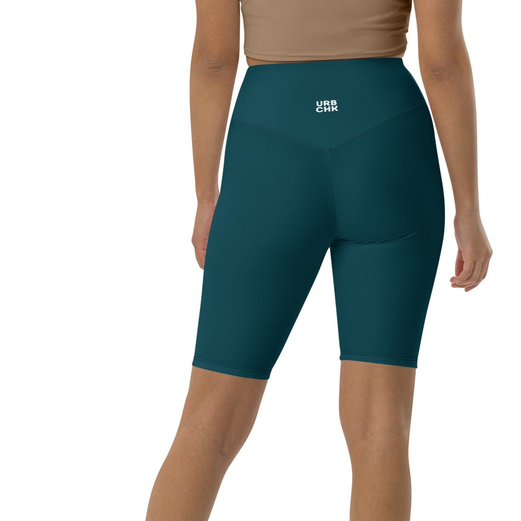 A woman wearing high-waisted green shorts with a visible brand logo on the left thigh.