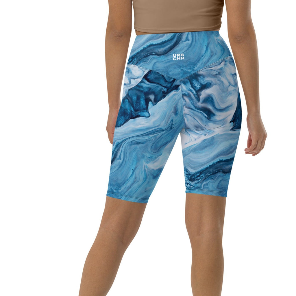 A pair of high-waisted shorts with a marbled blue and white ocean waves pattern, featuring a double-layered waistband and a pocket in the back.